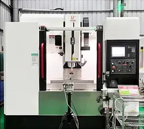 Laser interferometer on a tripod set up in front of a vertical machining center